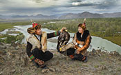 Two Eagle Hunters on Cliff above River Valley